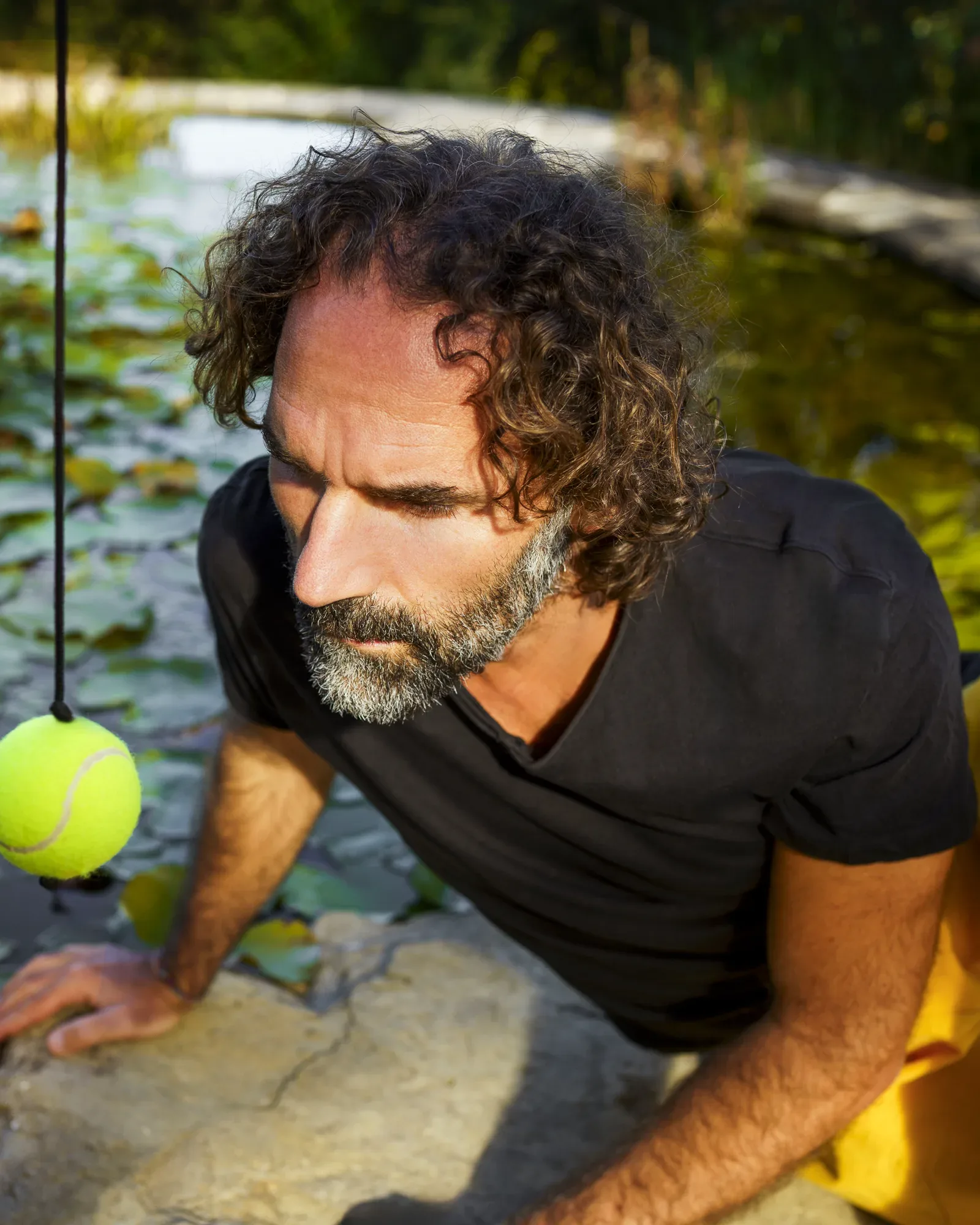 Stefano Spaccapanico Proietti, accanto a uno stagno, osserva una pallina sospesa a un filo
